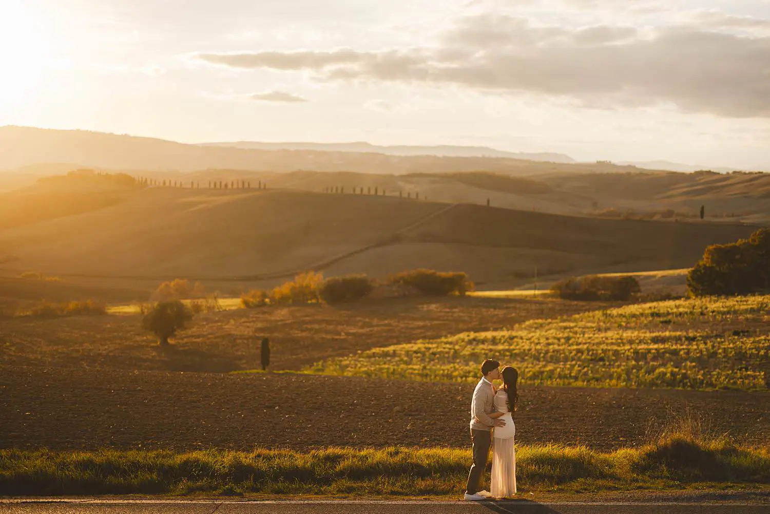 Romantic and dreaming engagement photo shoot in the iconic Tuscan landscapes near Pienza during golden hour