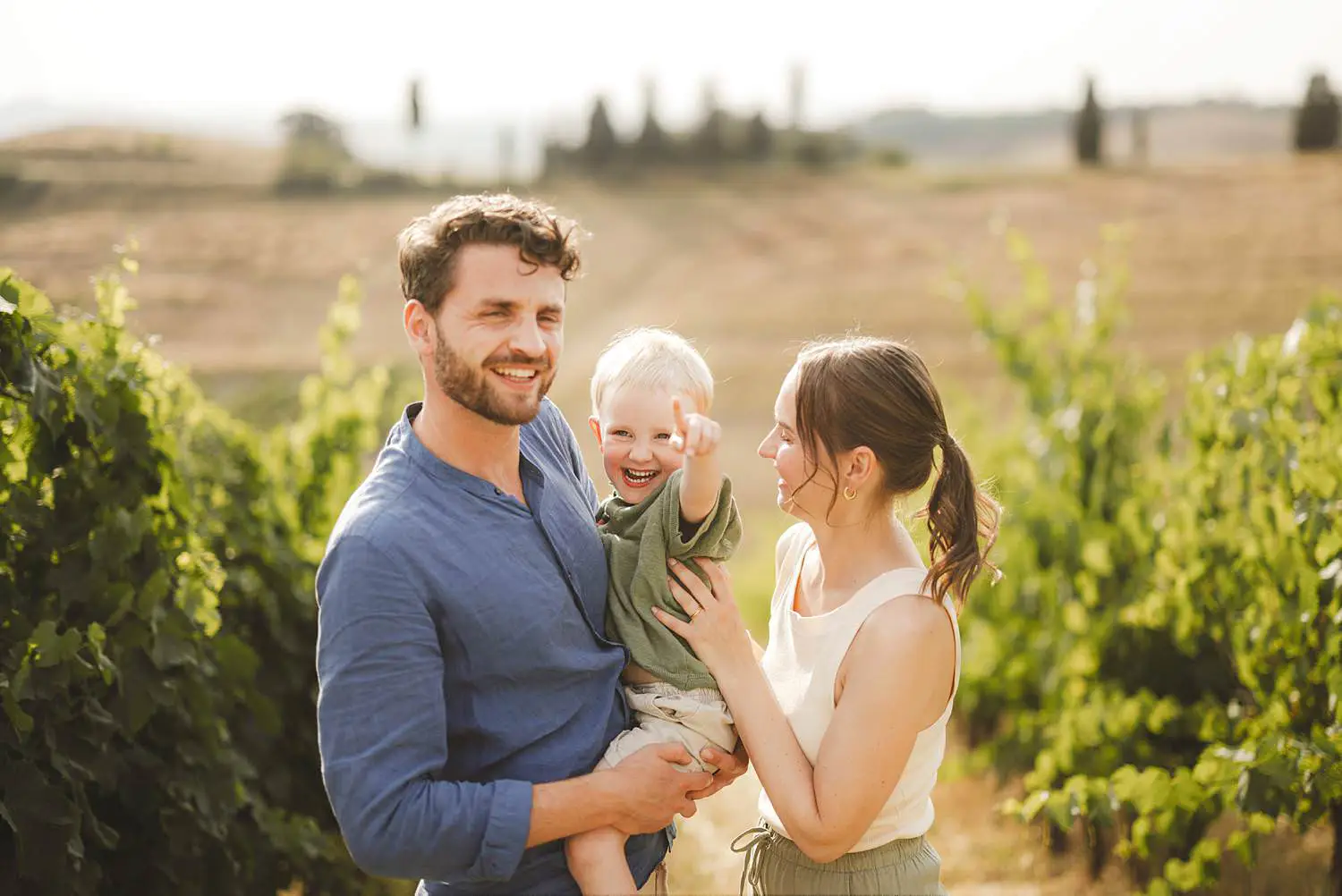 Joyful and smiling spontaneous family photos into Tuscan vineyards of Certaldo Alto