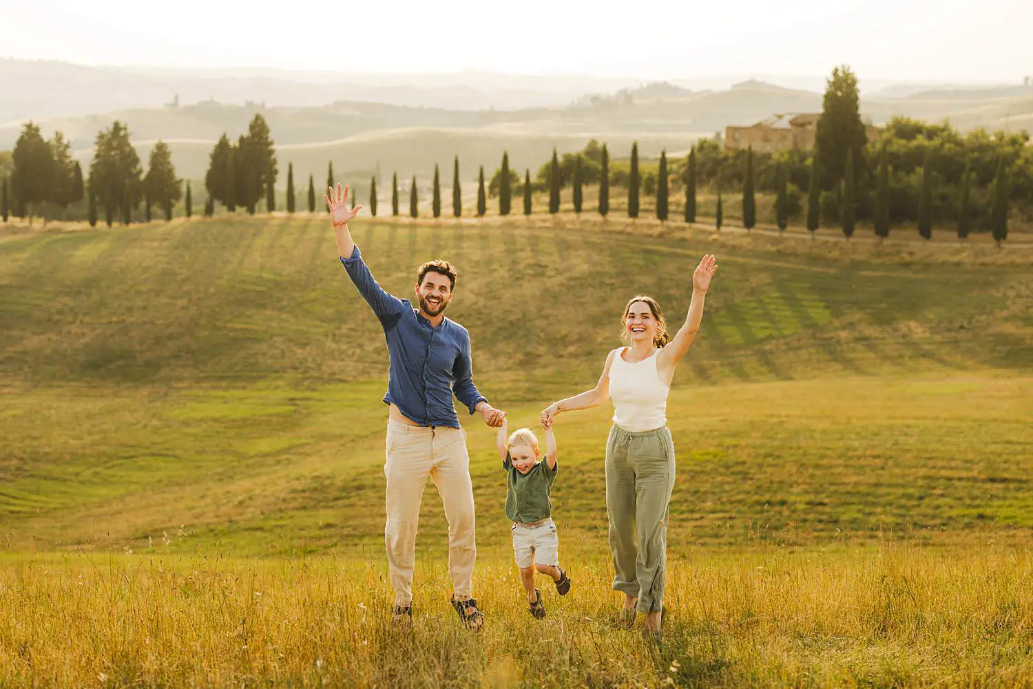 An exciting and fun family photo session in Certaldo Alto during golden hour and evocative cypresses lined path trees