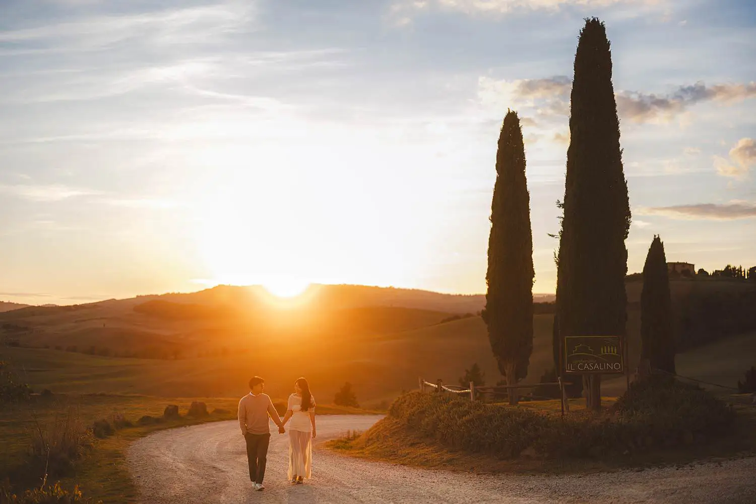 Romantic and dreaming engagement photo shoot in the iconic Tuscan landscapes near Pienza with cypresses trees
