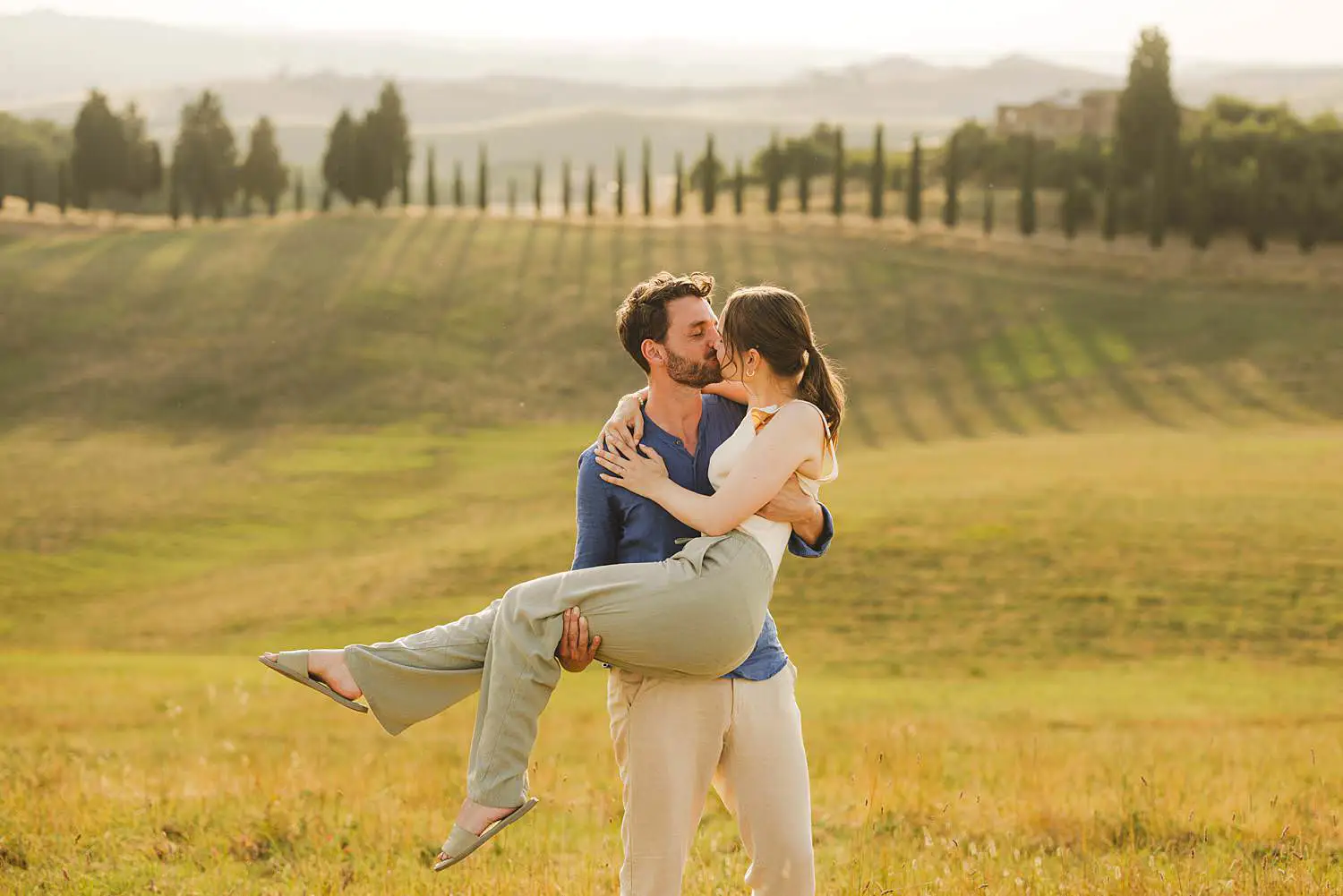 Lovely and elegant family photo with cypresses trees in Certaldo Alto countryside at golden light