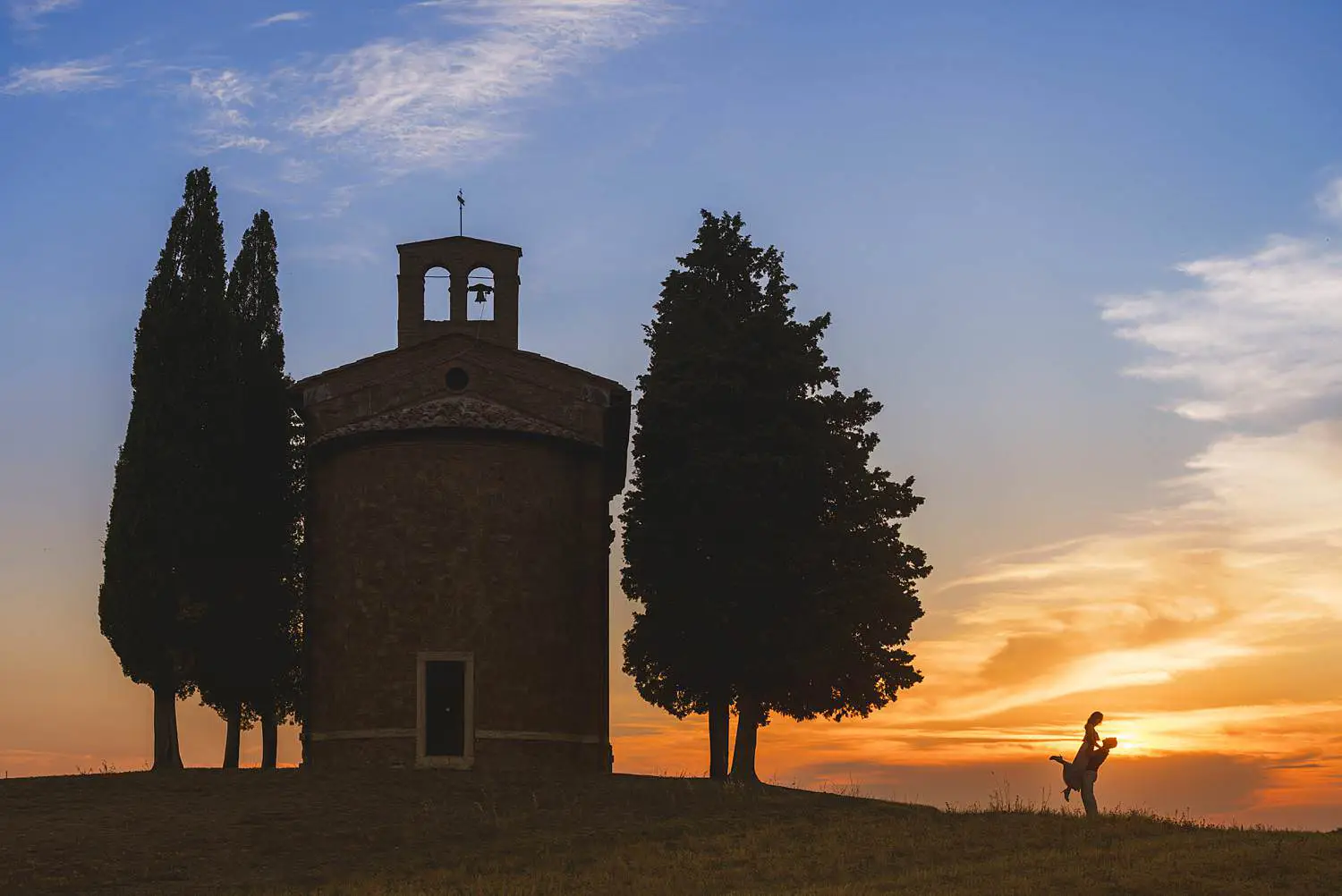 Joyful engagement photo session between Pienza and the Iconic Chapel of Vitaleta at sunset
