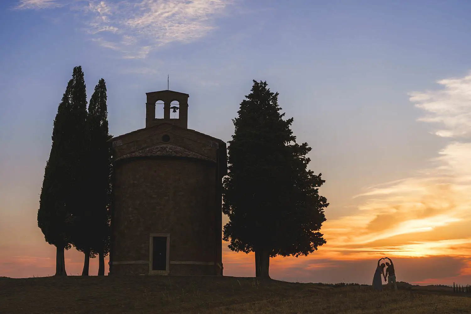 Joyful engagement photo session between Pienza and the Iconic Chapel of Vitaleta at sunset