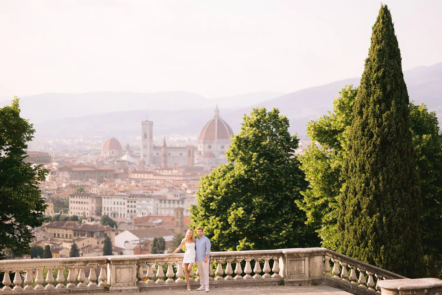 Couple at San Miniato al Monte terrace overlooking Florence Cathedral during a pre-wedding photoshoot.