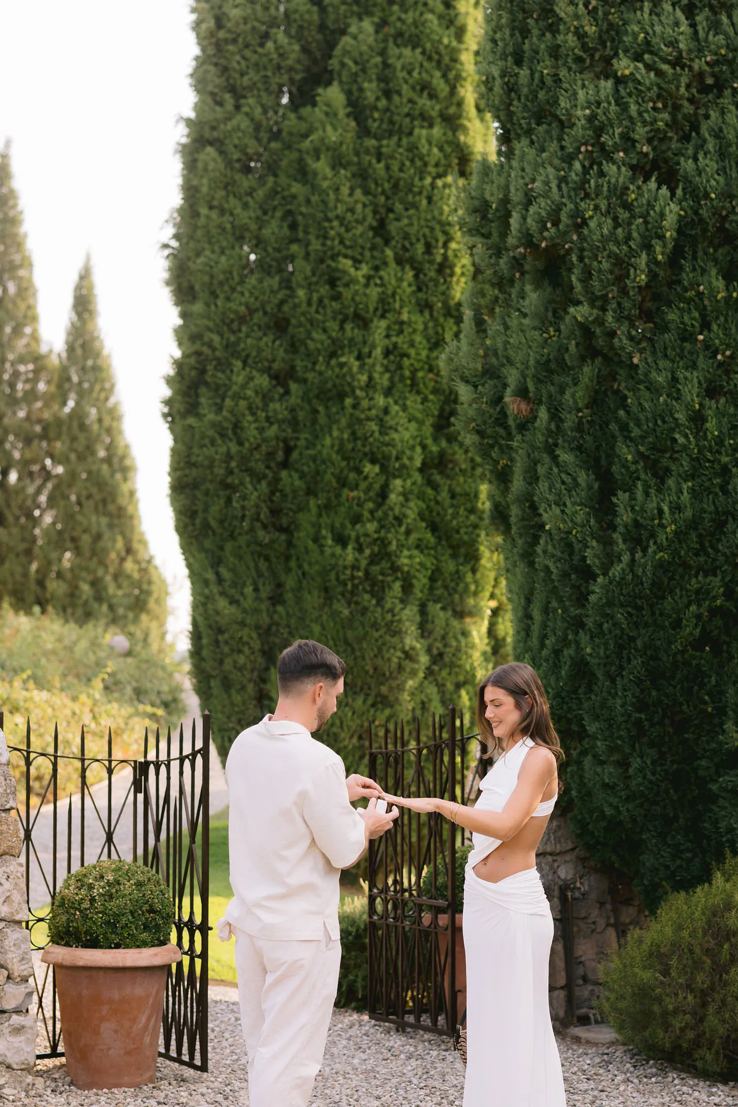 Dekota and Aiden proposal session beside the cypresses and garden gate.
