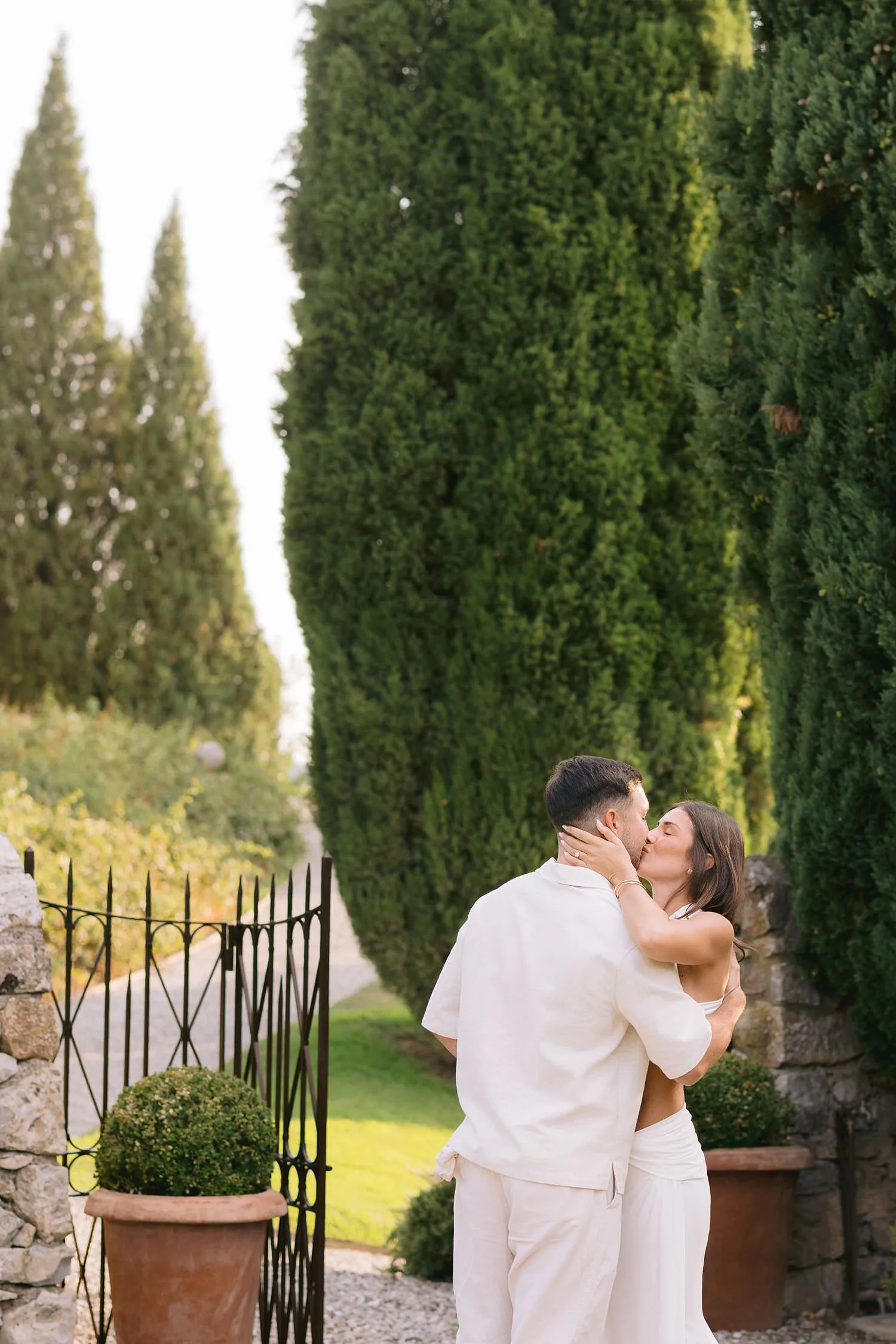 Dekota and Aiden kissing beside the garden gate after their surprise proposal.