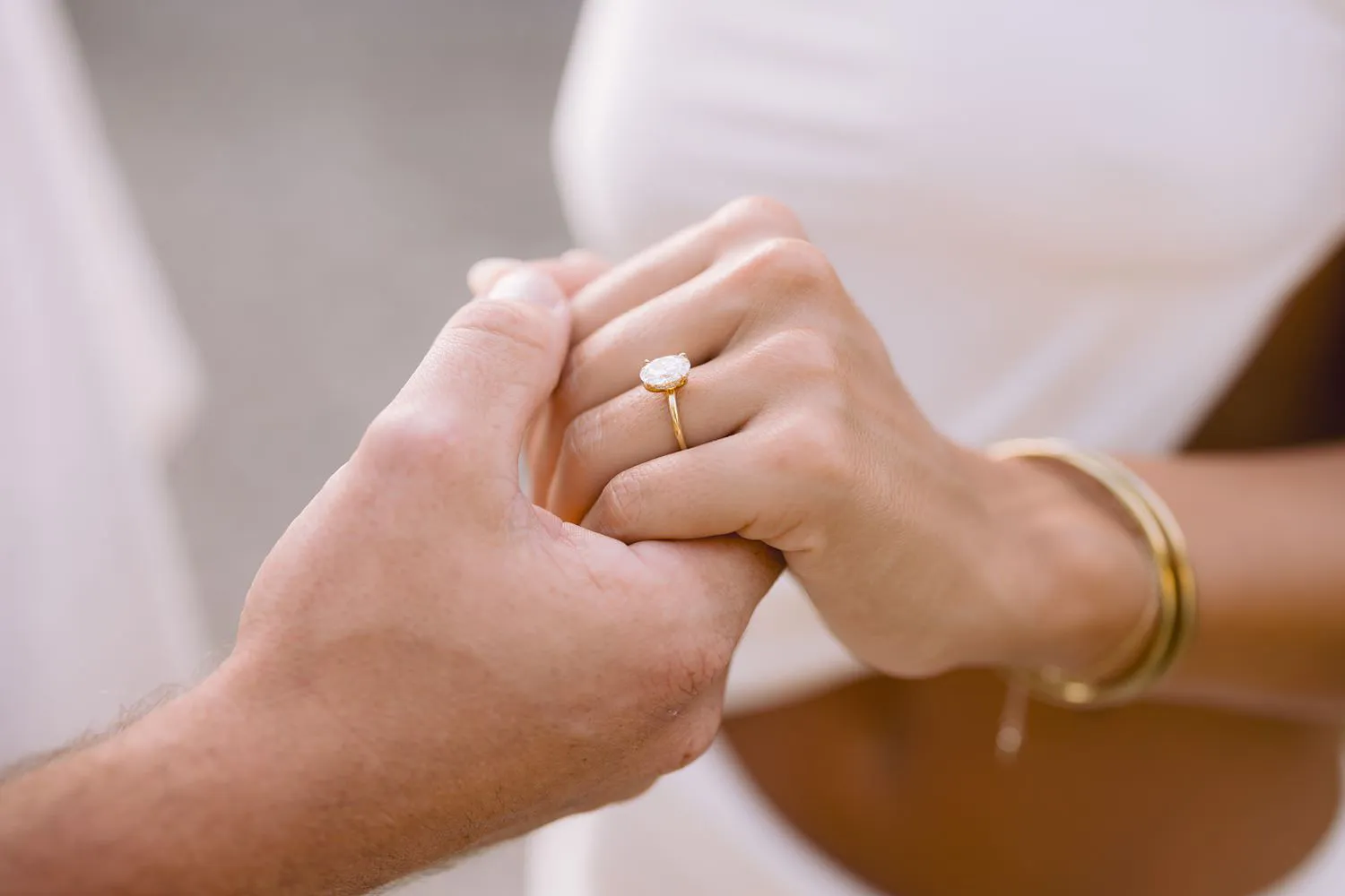 Close-up of Dekota and Aiden holding hands, showing the engagement ring.