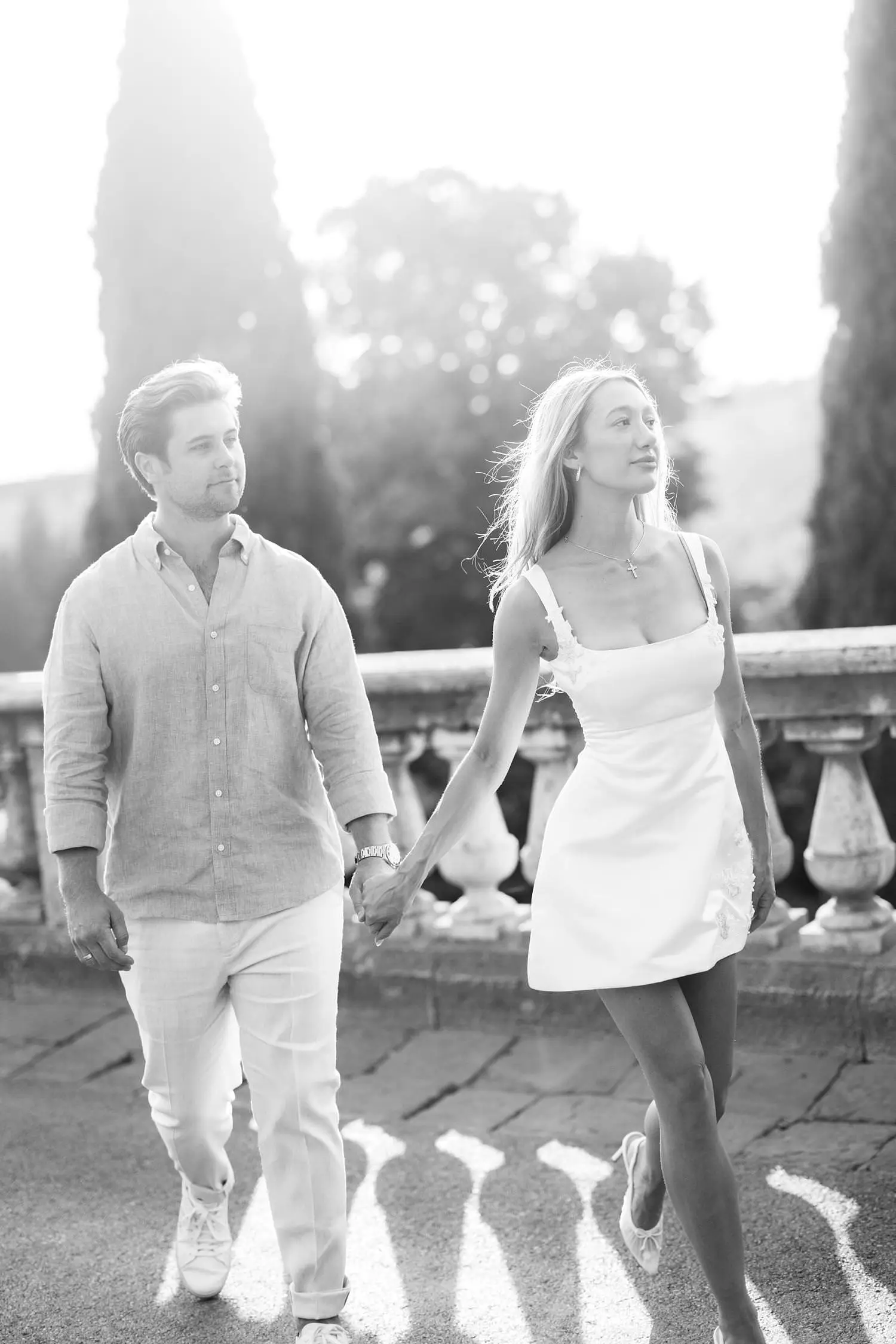 Black-and-white portrait of a couple walking hand in hand at San Miniato al Monte in Florence.