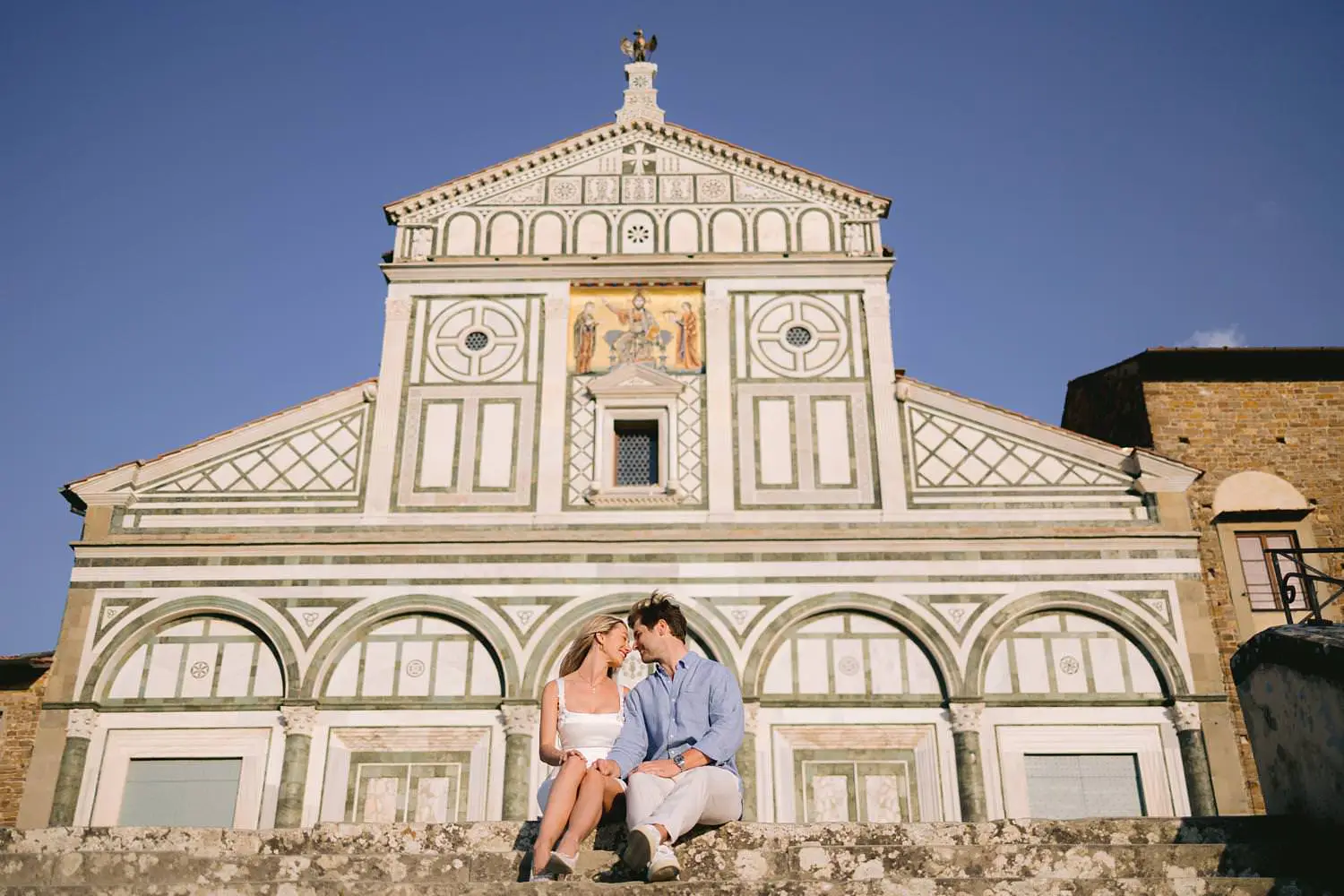Couple sitting on the steps of the Basilica of San Miniato al Monte in Florence.
