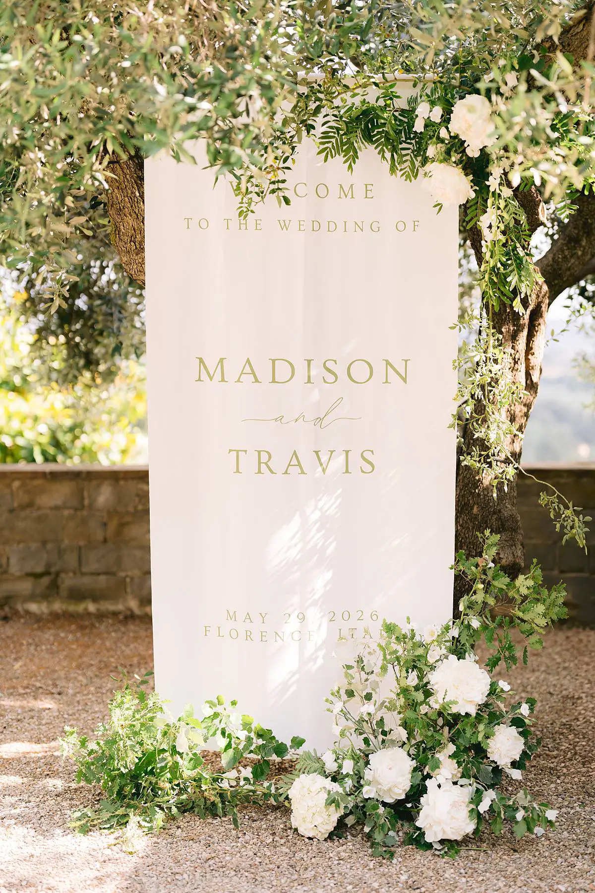 Wedding welcome sign framed by white flowers at Villa Le Fontanelle.
