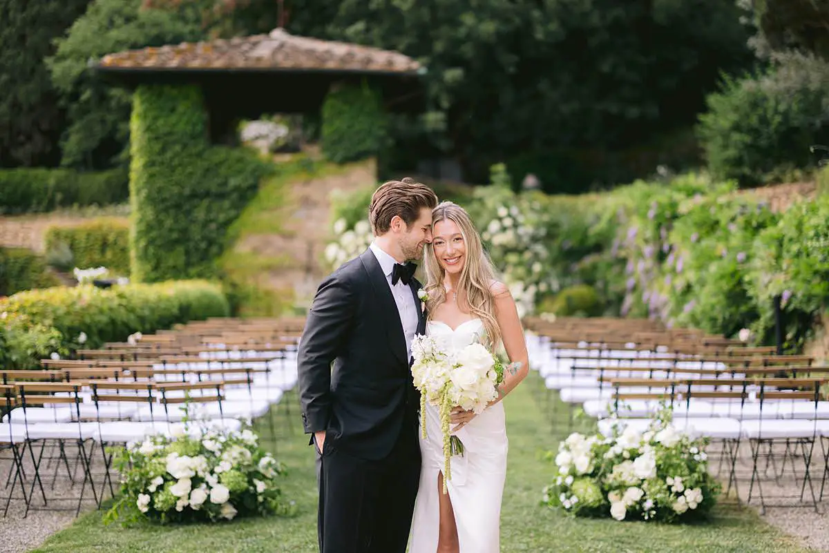 Madison and Travis stand together in the garden ceremony aisle at Villa Le Fontanelle.