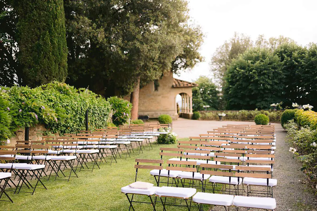 Rows of wooden chairs arranged for an outdoor ceremony at Villa Le Fontanelle.