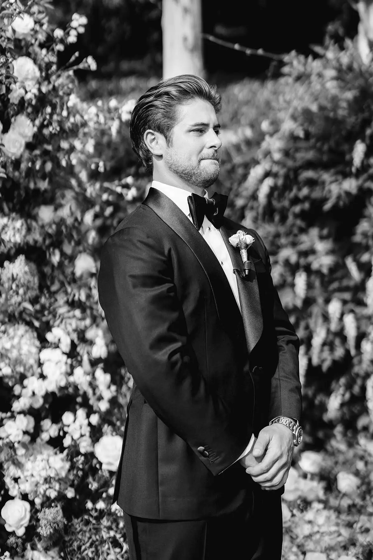 Groom in a tuxedo waits the bride in the Villa Le Fontanelle garden.