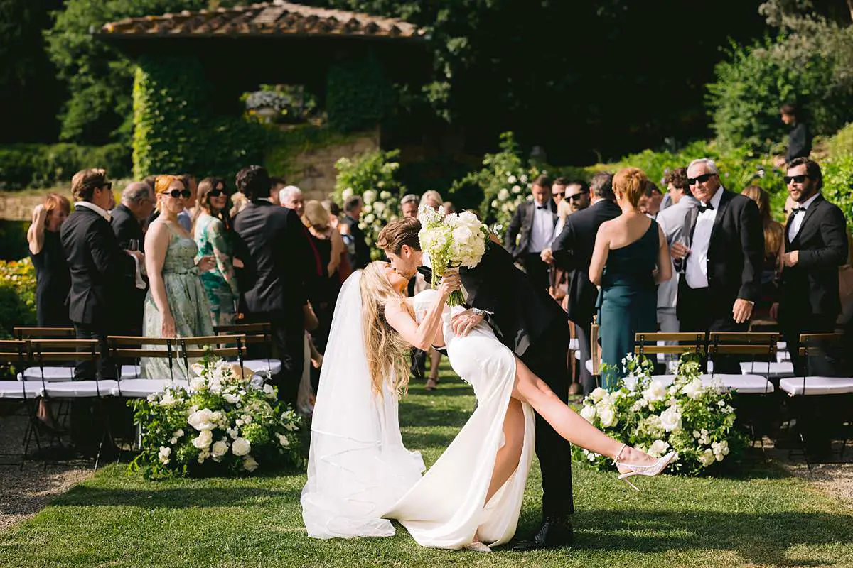 Travis lifts Madison in celebration after their Villa Le Fontanelle wedding ceremony.