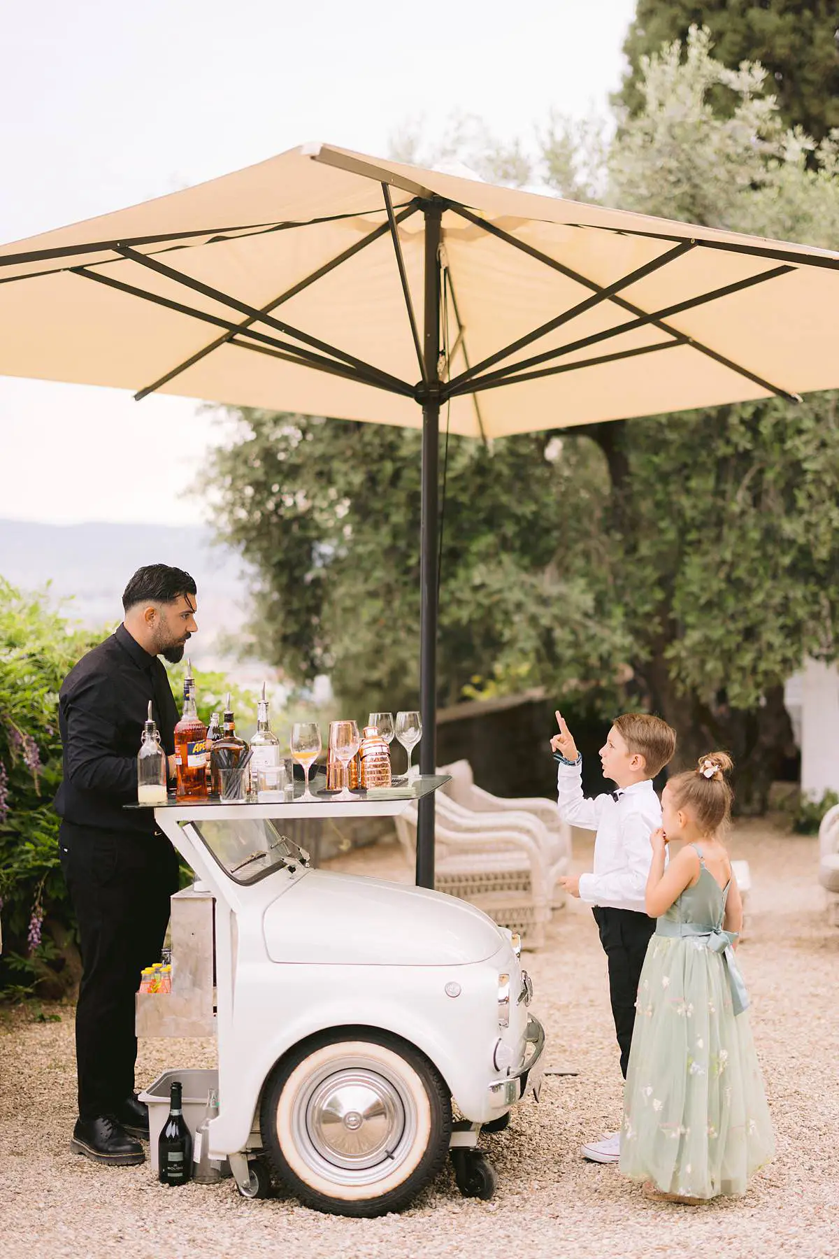 Children visit a vintage aperitivo cart during the Villa Le Fontanelle wedding reception.