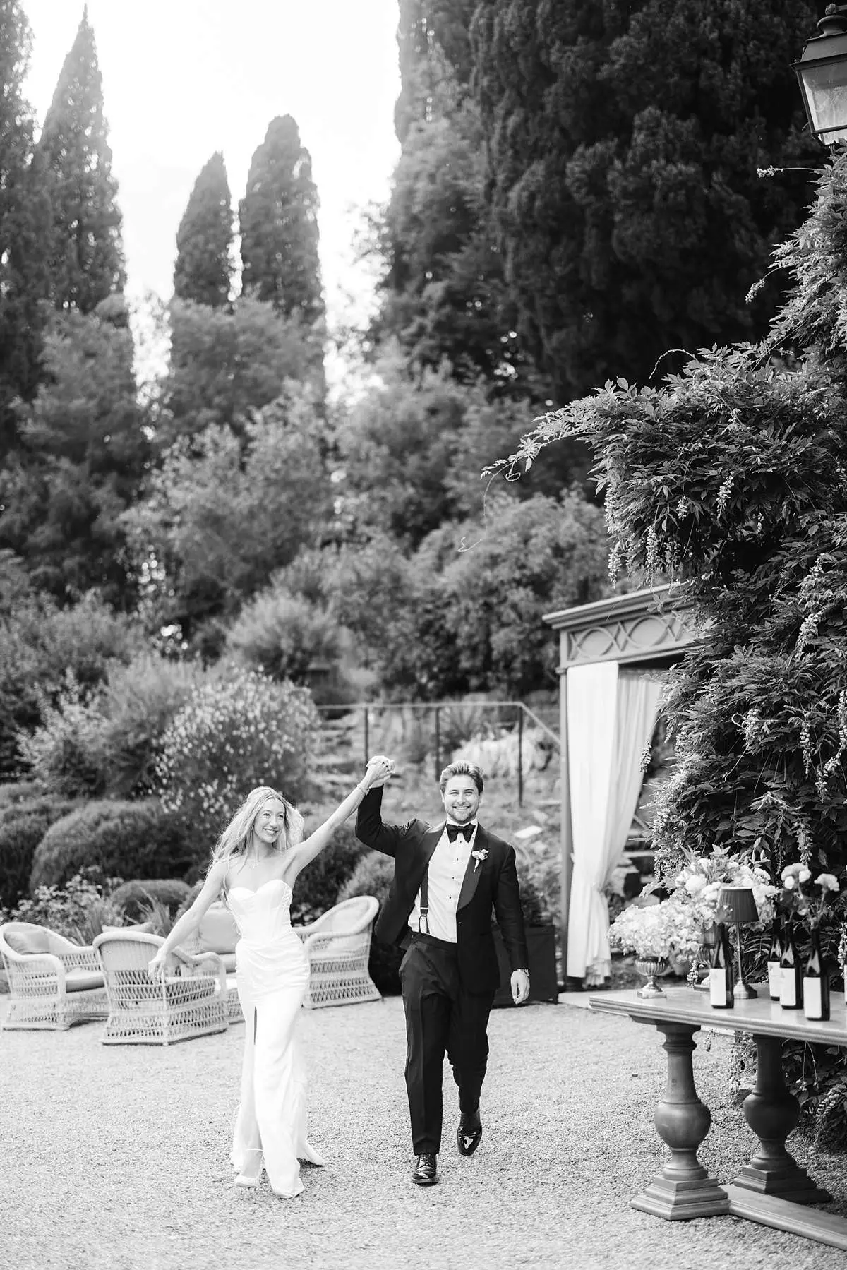 Newlyweds walk hand in hand through the gardens of Villa Le Fontanelle.