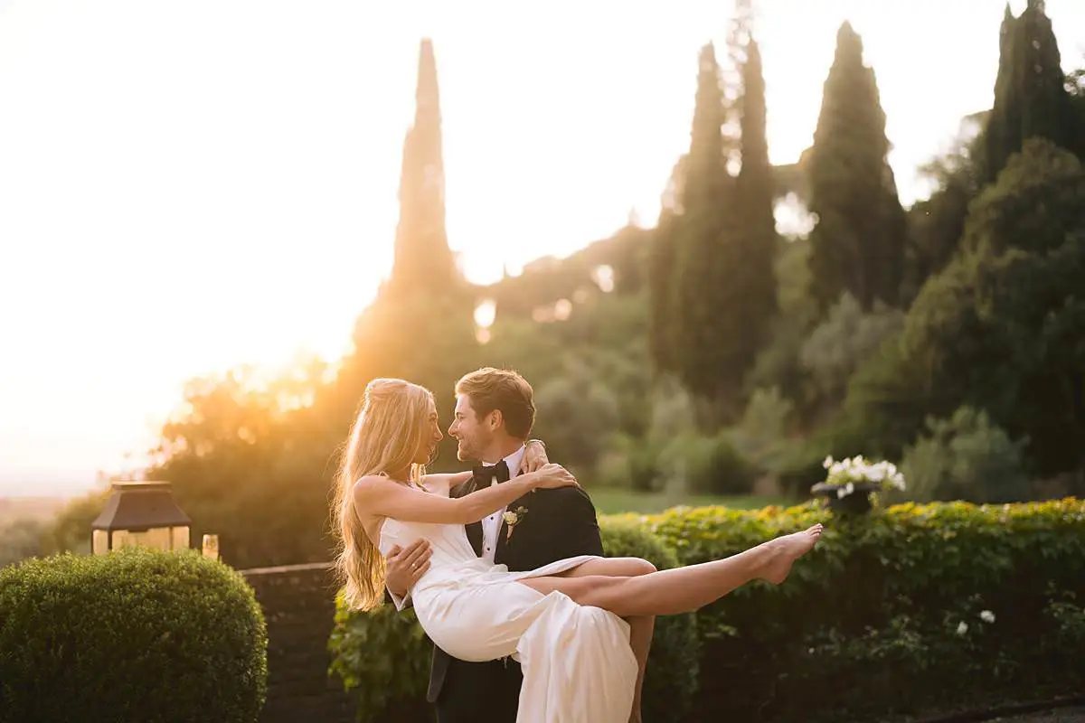 Travis holds Madison in the Villa Le Fontanelle garden at sunset.