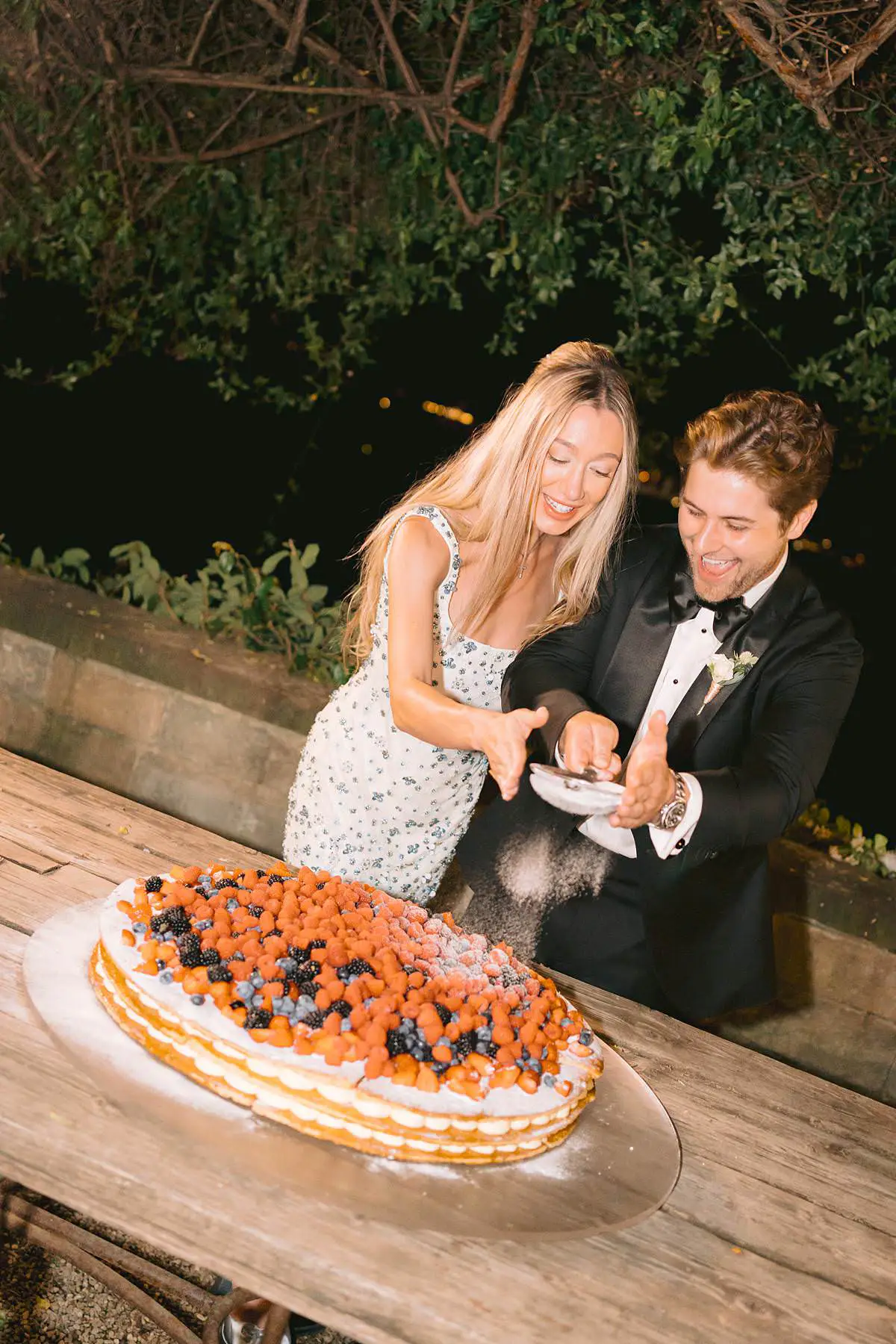 Madison and Travis cut a berry-topped wedding cake during their Villa Le Fontanelle reception.